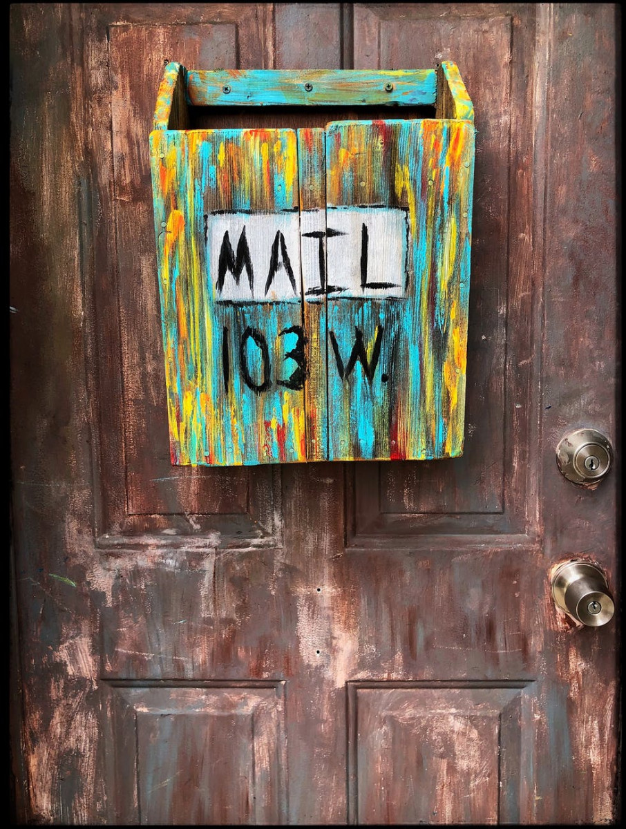 multi coloured wooden mailbox mounted on door