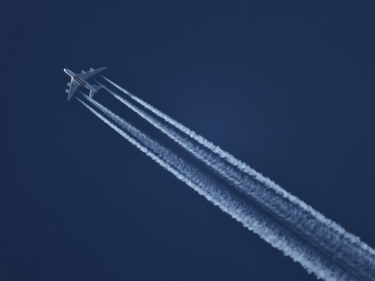 flying plane leaving contrails