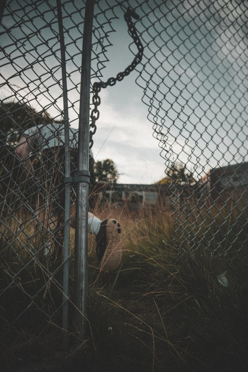 person going through a broken wire fence