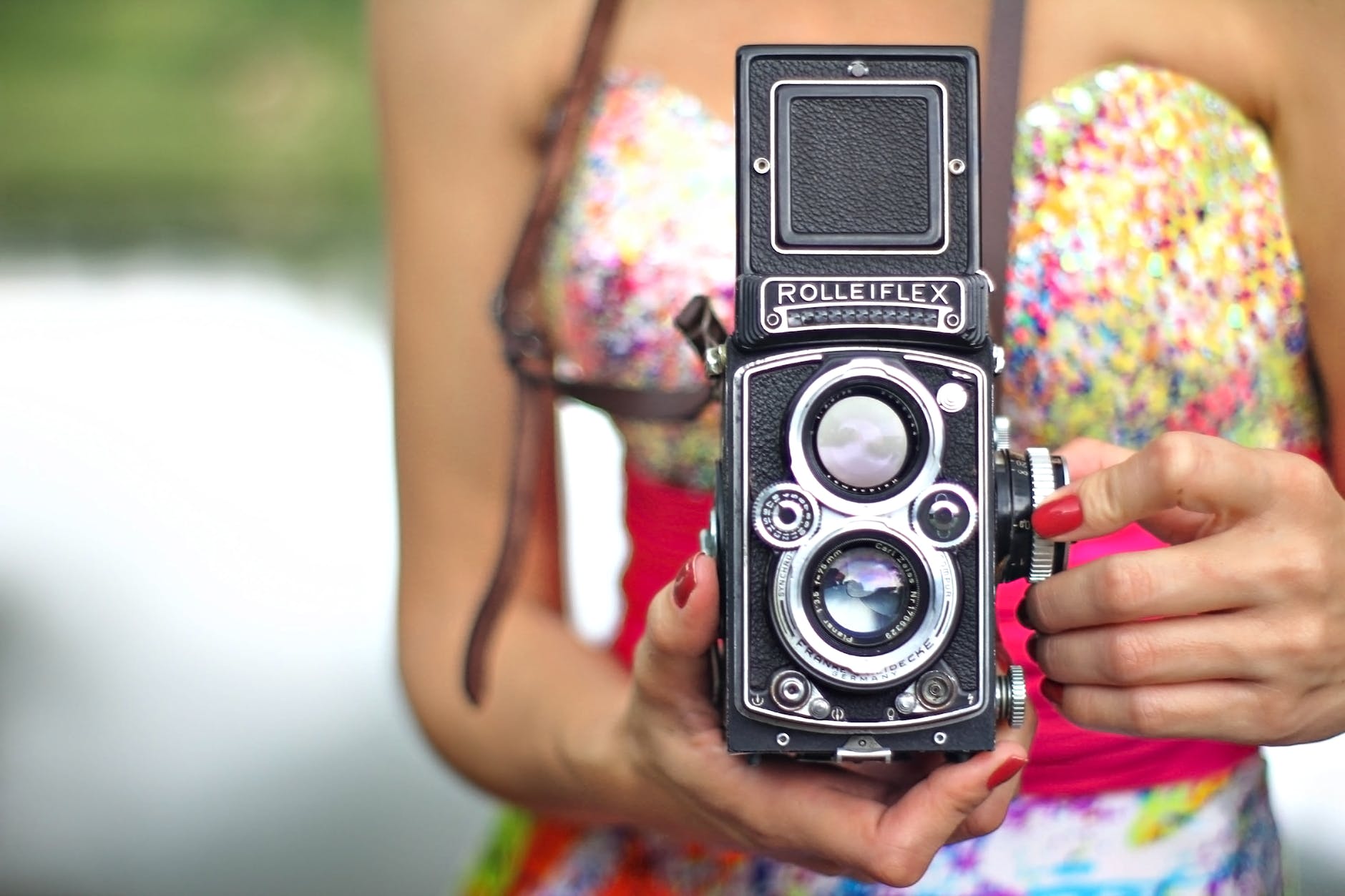 person holding black and silver vintage camera